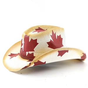 Close-up of woven straw cowboy hat featuring red maple leaf prints and wide brim