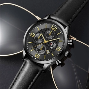 Gros plan d'une montre à quartz pour homme en cuir noir avec calendrier et lunettes de soleil