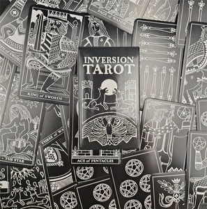 Macro detail of Inversion Tarot cards and box featuring silver line art on black cardstock