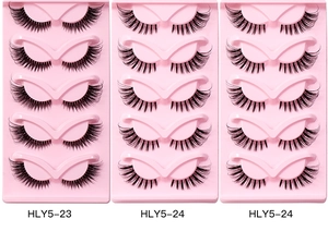 Detail view of 5 pairs of curled synthetic faux mink eyelashes on pink plastic trays