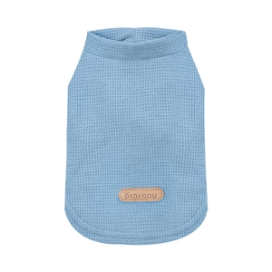 Close-up of light blue waffle knit fabric and leather logo tag on a dog vest