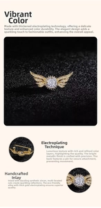 Detail of angel wing brooch with sparkling zircons and a glossy golden finish