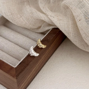 Orecchini a perno croissant in argento 925 oro e argento esposti su portagioie in legno