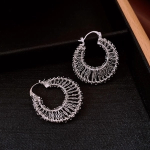 Detail view of silver hollow chain woven hoop earrings with smooth metallic finish