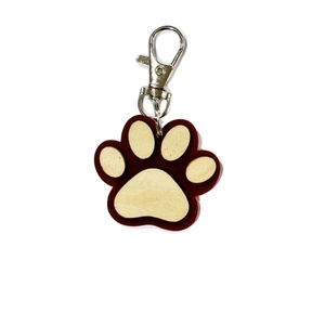 Close-up of wooden paw print keychain with red acrylic base and silver swivel clasp