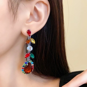 Detailed close-up of colorful rhinestone leaf tassel earrings with a teardrop pendant
