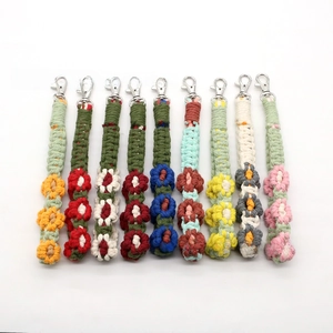 Detail showing various colorful hand-woven floral keychains with sturdy metal lobster clasps
