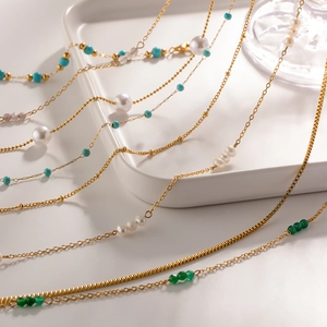 Detail of 18K gold-plated stainless steel necklaces with pearls and turquoise beads