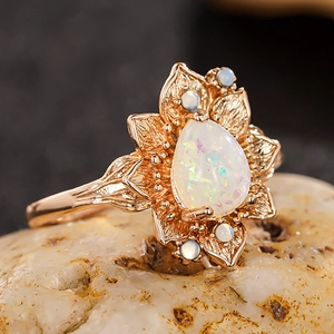 Vista macro dettagliata di un anello a fiore in oro rosa con opale a goccia e dettagli sui petali