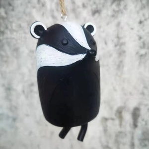 Detailed close-up of a hand-painted resin badger hanging ornament with rustic textures