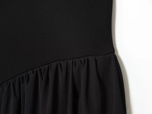 Close-up of black mesh stitching and pleated knit texture on the elegant vacation dress