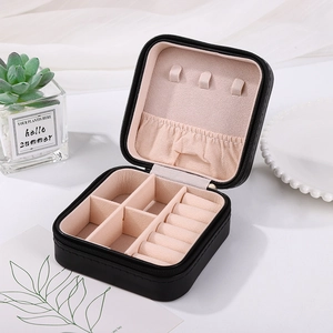 Detail of portable square jewelry box with zipper closure and velvet interior storage