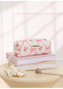 Detail of white quilted cosmetic bag with pink roses and Beenlove ribbon pull