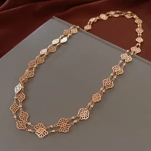 Retro golden long chain necklace with geometric floral cutout design on silk background