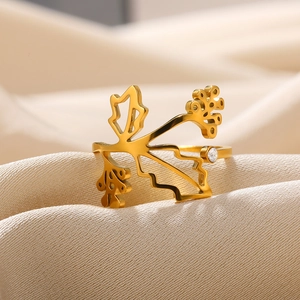 Detail of gold-plated leaf ring with zircon stone on elegant beige pleated fabric
