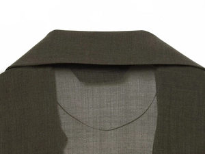 Detailed view of dark olive green asymmetric lapel collar and linen fabric texture