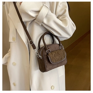 Detail of dark brown faux suede and plush shearling texture on women's handbag