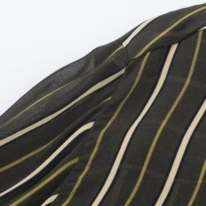 Detail shot of green vertical striped shirt showing seam stitching and woven fabric