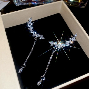 Close-up of silver drop earrings with marquise zircon leaves and long tassel chains