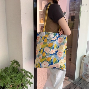Gros plan du sac cabas en toile à fleurs style peinture à l'huile avec anses jaunes