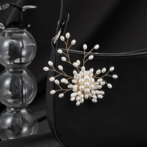 Elegant vintage pearl tree brooch in gold metal finish pinned on a black bag