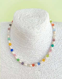 Detail of beaded necklace with irregular white pearls and colorful round glass beads