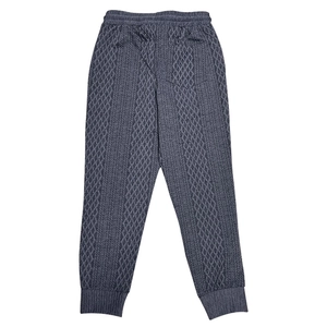 Detail view of grey knit jogger pants with textured diamond pattern and elastic waistband