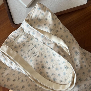 Macro detail of the floral cotton fabric texture and printed label on the shoulder bag