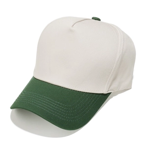 Detail of five-panel trucker hat featuring cream cotton fabric and green curved brim