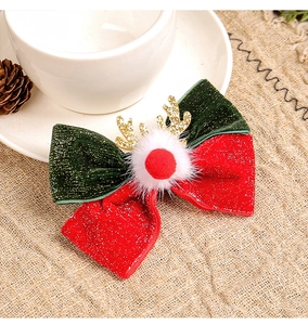 Close-up of a festive Christmas reindeer antler hair clip with a red bow and white pompom