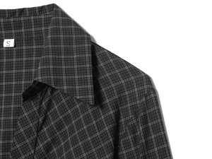 Detailed close-up of dark grey plaid shirt collar with S size tag on white background