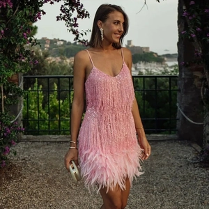 Détail de robe rose à franges montrant des paillettes et un ourlet en plumes