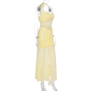 Detail of light yellow lace dress featuring sheer mesh panels and tiered ruffle hem