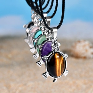 Vue détaillée de pendentifs tortue avec diverses pierres naturelles et cordons