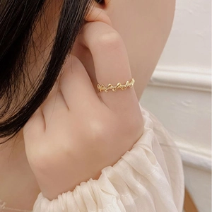 Close-up of a minimalist gold wave textured ring featuring elegant woven lines