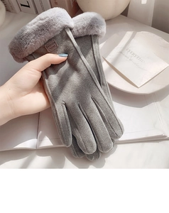 Close-up of gray suede gloves with faux fur cuff and fashion label on the back