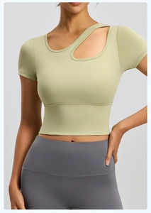 Dettaglio di un crop top yoga verde chiaro con un elegante taglio asimmetrico sulla spalla