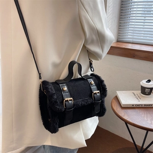 Fashionable black faux fur and leather cylinder handbag worn by a model in a cafe setting