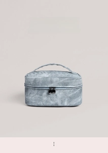 Macro view of blue denim texture makeup bag featuring premium dual metal zippers