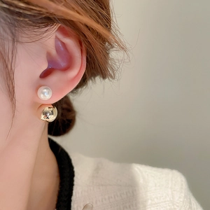 Detail showing gold-plated pearl earrings worn by a model in a two-way wearing style