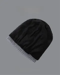 Detail of winter beanie knit texture and ribbed cuff in black and grey contrasting colors