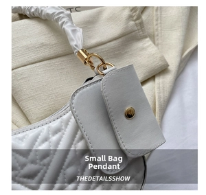 Detail of white quilted leather bag with golden hardware and mini pouch charm