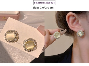 Detailed view of 2x2cm square cat-eye stone earrings with rhinestone halo on model