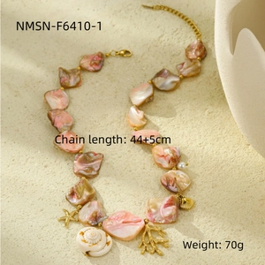 Detail of pink shell beach necklace with golden starfish and coral textured pendants