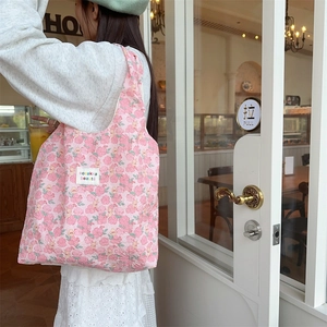Detailed back view of pink floral quilted tote bag with white woven brand label