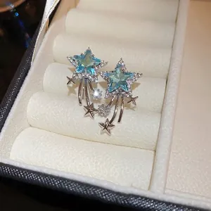 Elegant silver star earrings with blue zircon in a premium textured jewelry box