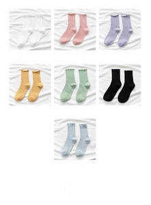 Detail of multi-color combed cotton mid-tube socks featuring delicate ruffle cuff edges