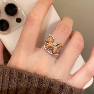Detailed macro view of rocking horse ring with silver metal and wood inlay on hand