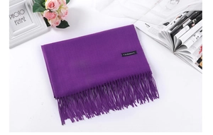 Detail view of purple cashmere scarf with soft fringe tassels and authentic woven label