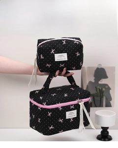 Detail of black quilted makeup bag set with pink bows and white polka dots pattern